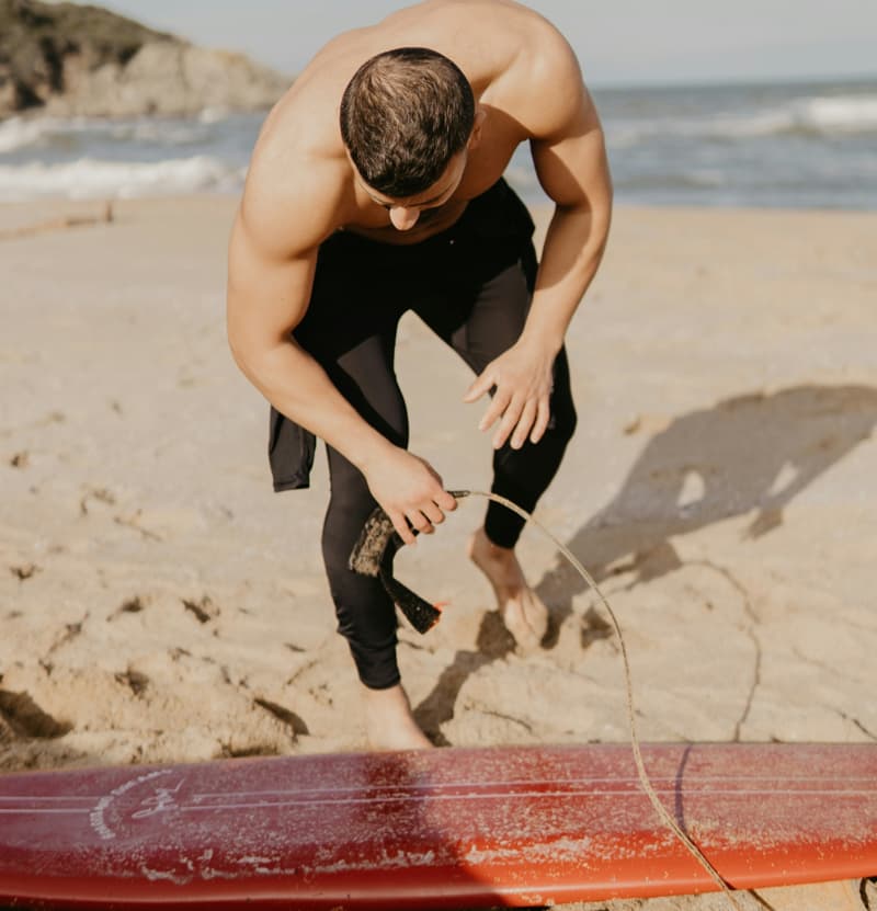 Surfista che controlla l'integrità della propria tavola da surf | Point Break School